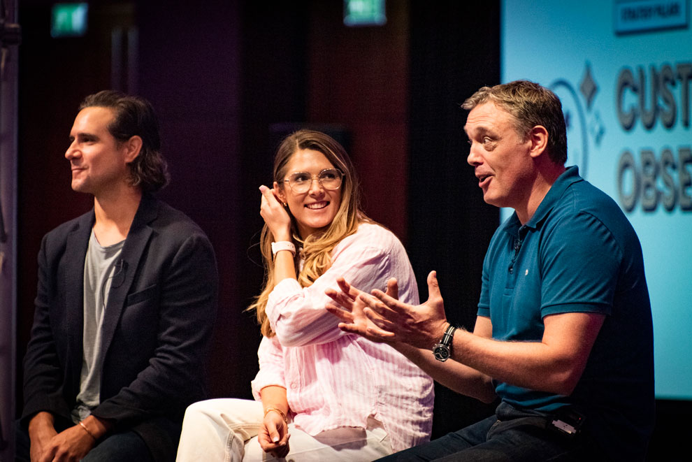 Three speakers on stage at a conference