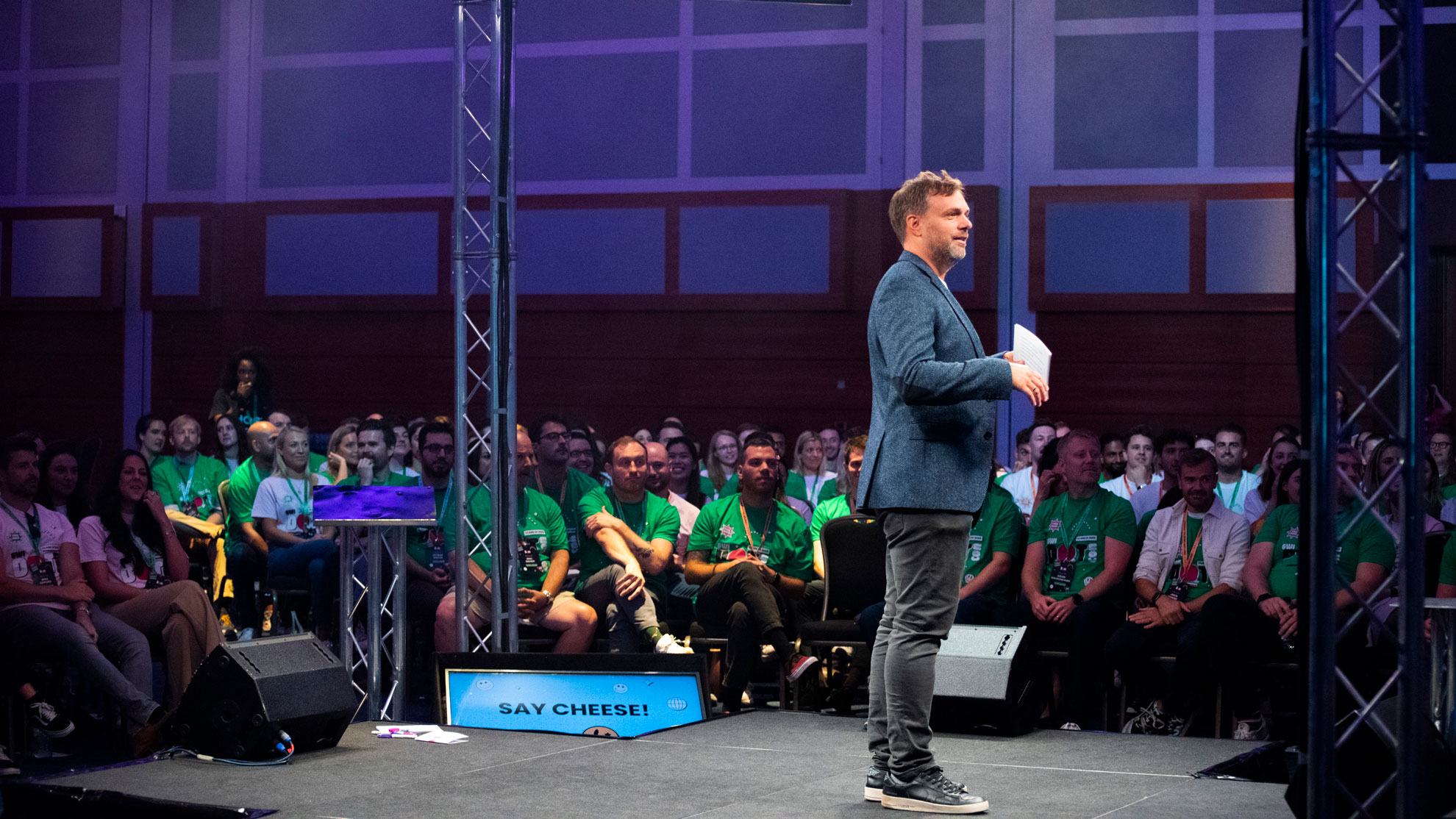 Smart casually dressed man talking to a crowd at a conference