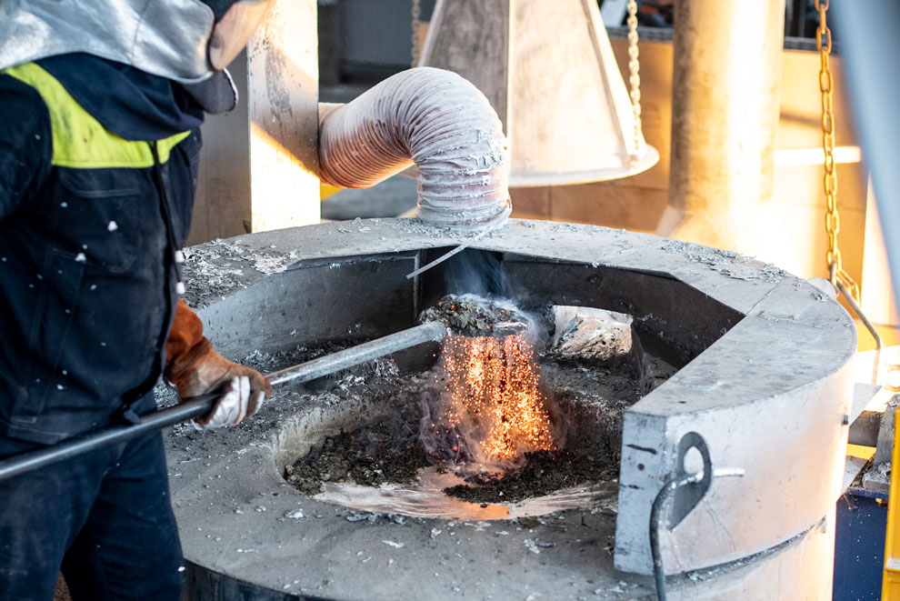 etal worker lifting molten metal from a furnace