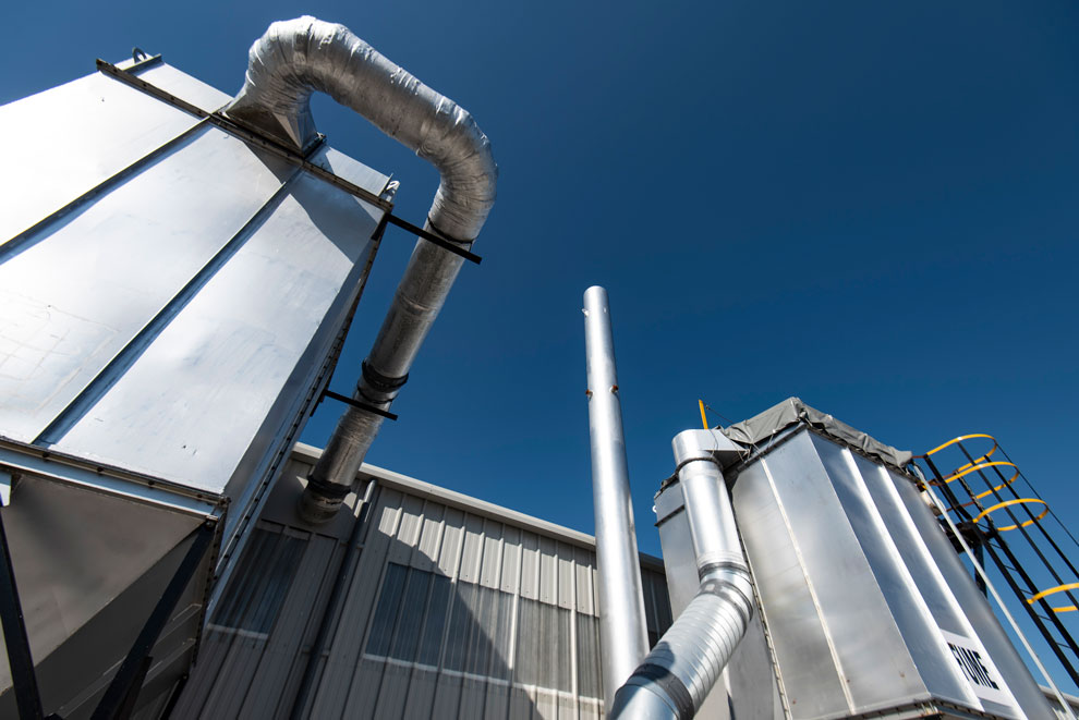 Exterior photography of a metal works plant. Industrial architecture against a clear blue sky.